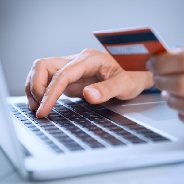 Close Up Of A Man Shopping Online Using Laptop With Credit Card